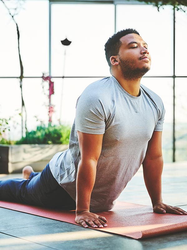 Young man practicing Upward Facing Dog Pose
